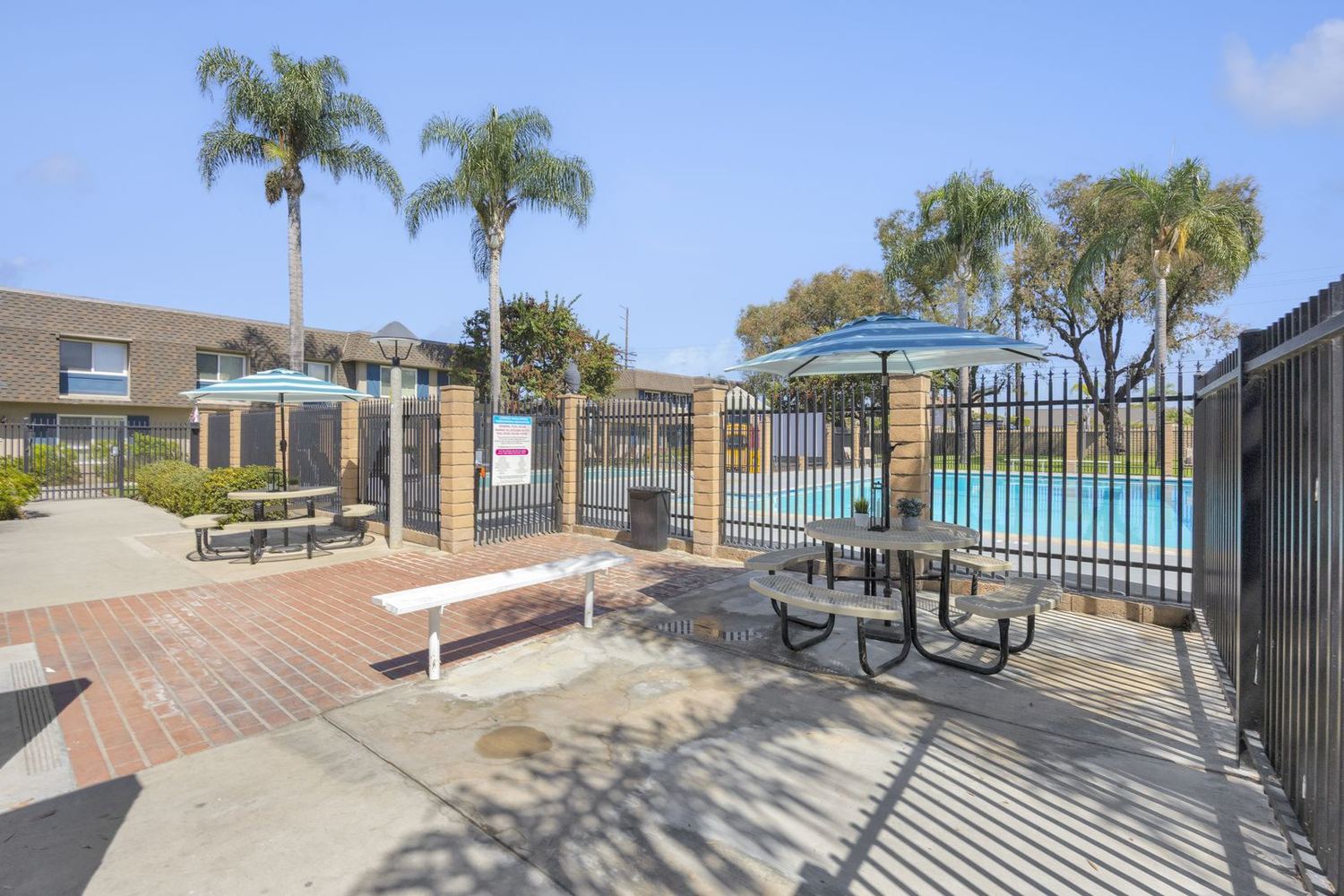 The brick patio and shade umbrellas between the Clubhouse and the pool
